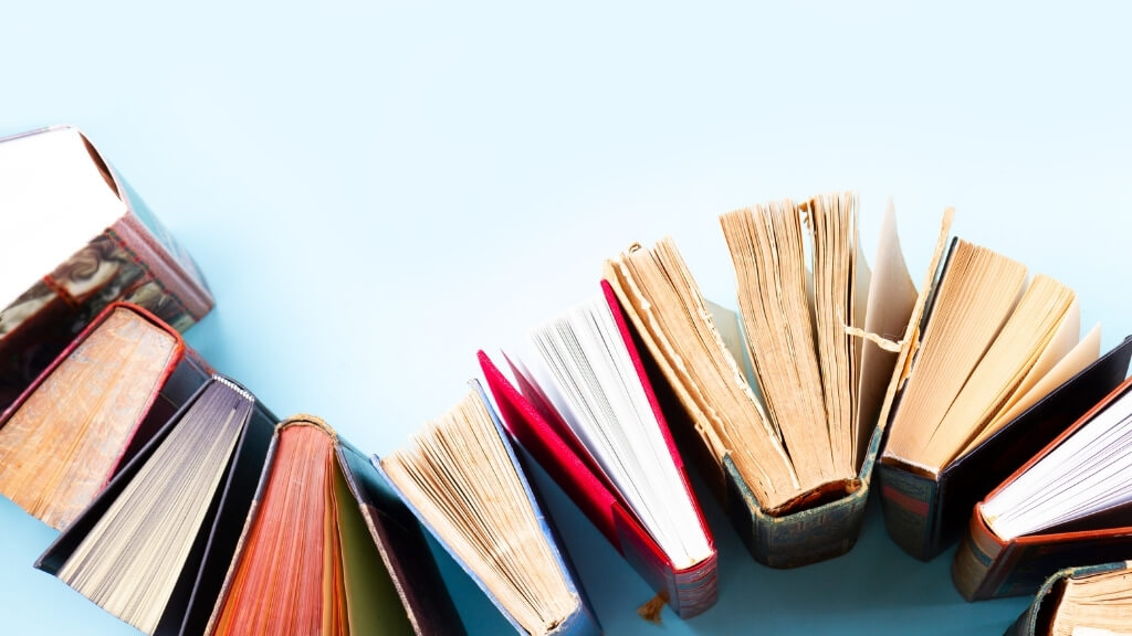 Books organized on a wave like line on light blue floor